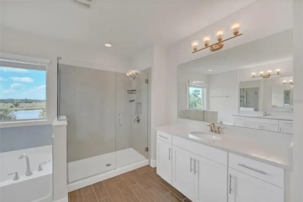 a bathroom with a sink a large mirror and shower