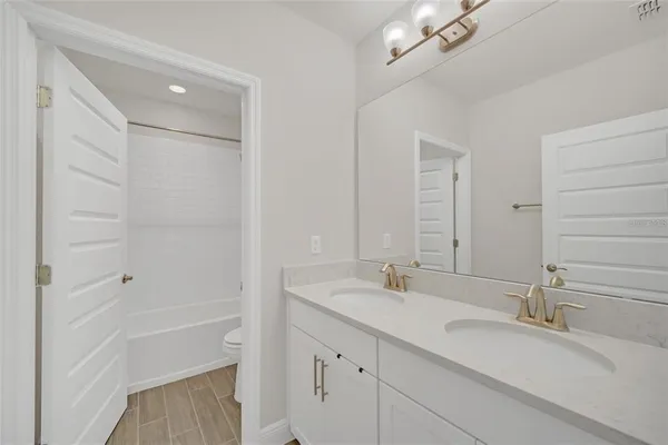 a bathroom with a double vanity sink a mirror and a bathtub