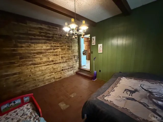 a bedroom with a bed and a chandelier