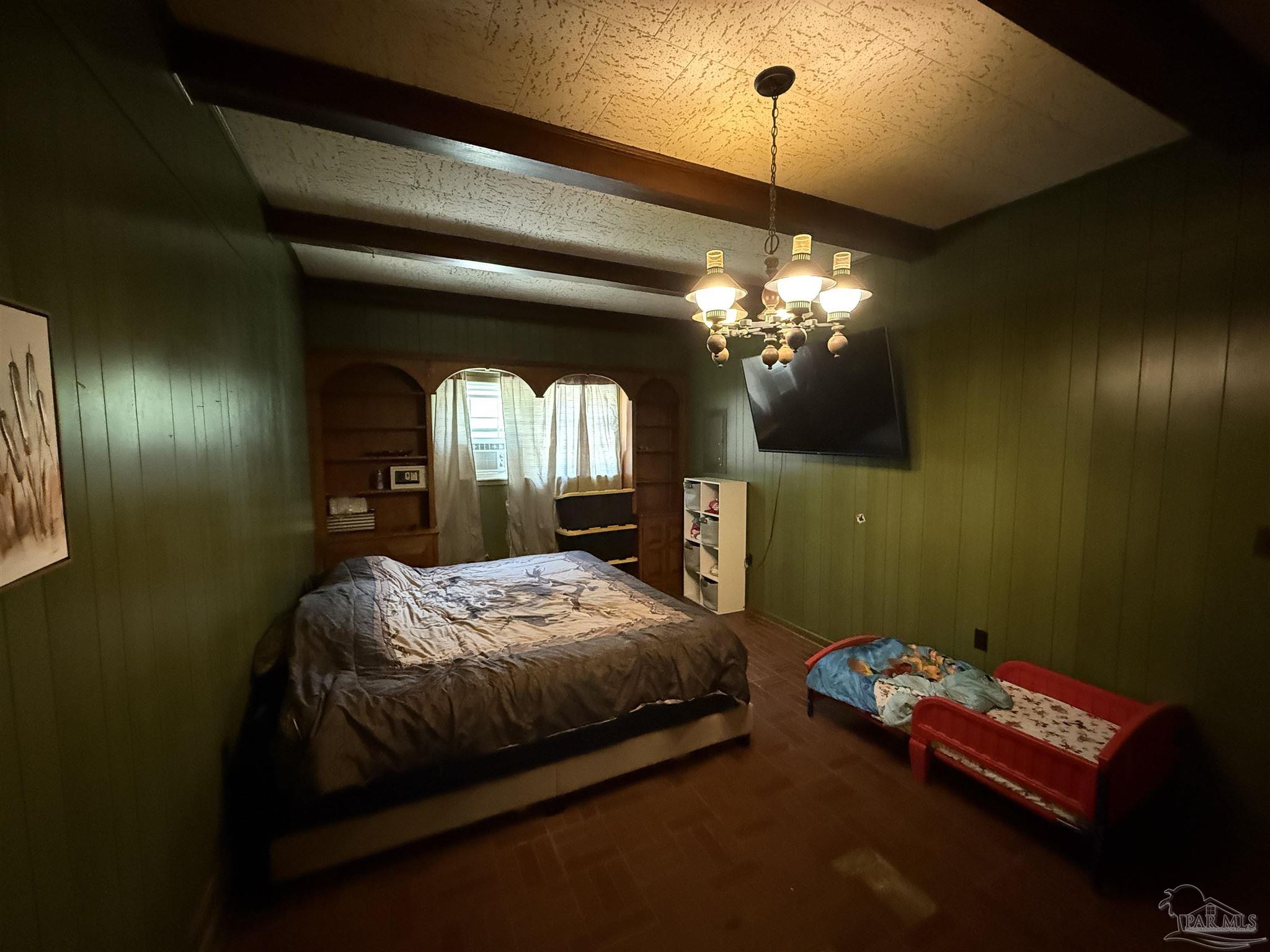 5031 Molino Road Molino, FL 32577 - Photo 15 of 37 a bedroom with a bed and a chandelier