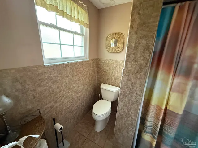 a white toilet sitting next to a window