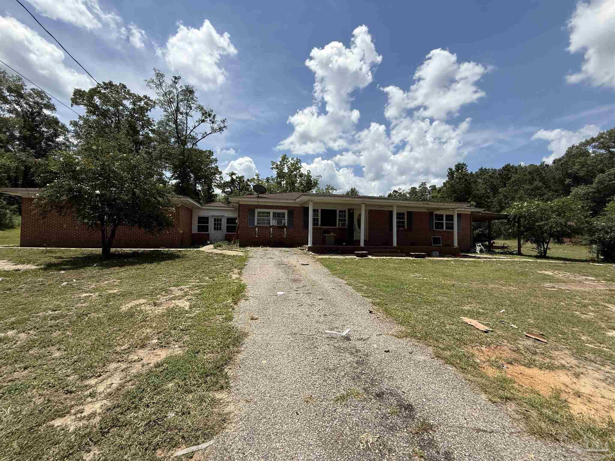 5031 Molino Road Molino, FL 32577 - Photo 4 of 37 a front view of a house with a big yard and a large tree