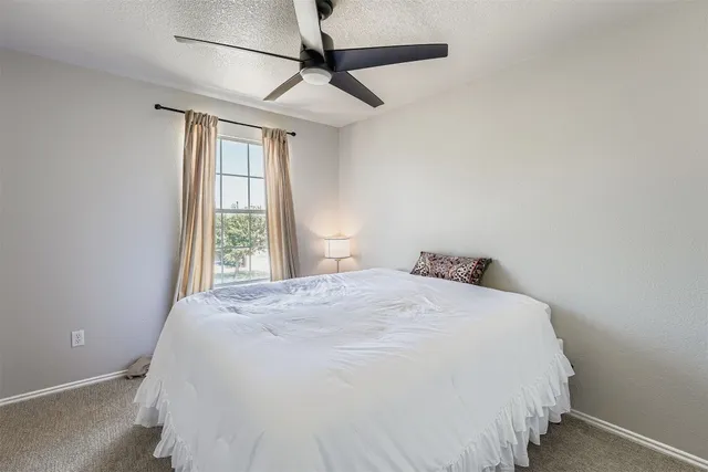 a large bed sitting in a bedroom next to a window
