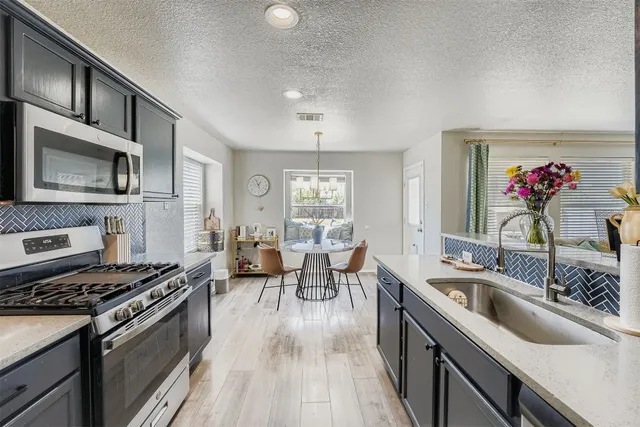 a kitchen with a sink stove top oven and microwave