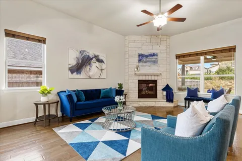 a living room with furniture a fireplace and a large window