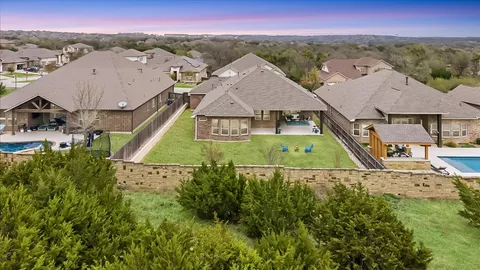 an aerial view of residential houses with outdoor space and trees