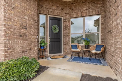 a view of a patio with a table and chairs and potted plants