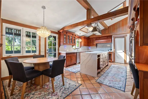 a dining room with stainless steel appliances granite countertop a stove a sink a dining table and chairs with wooden floor