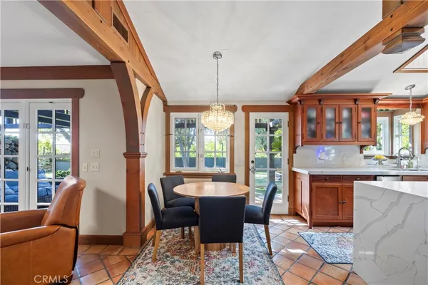 a dining room with furniture a chandelier and wooden floor