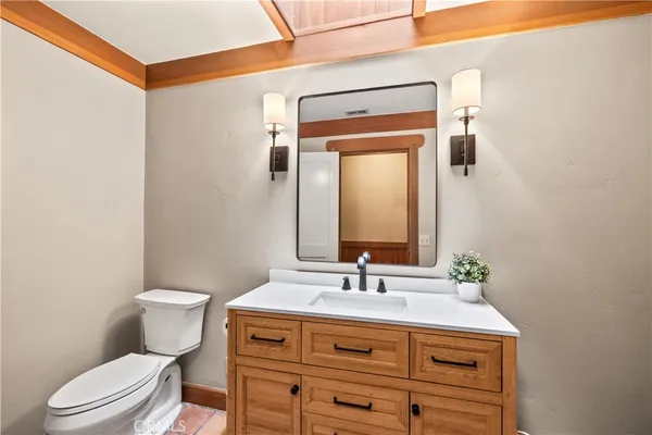 a bathroom with a toilet sink vanity and mirror