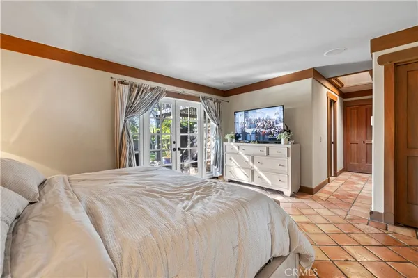 a large white bed in a bedroom next to a window