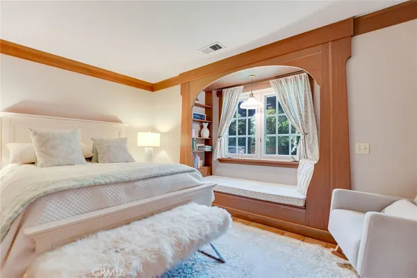 a bedroom with a bed and a large window