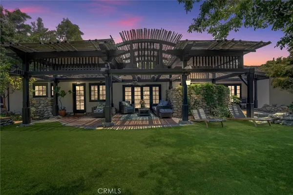 a view of a house with a yard fire pit and outdoor seating