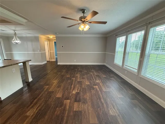 an empty room with wooden floor and staircase