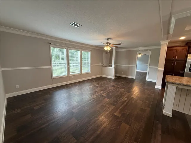 an empty room with wooden floor and window