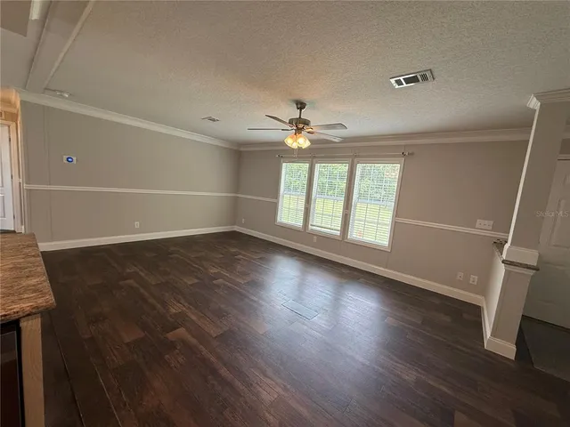 a view of a living room a kitchen and a stove