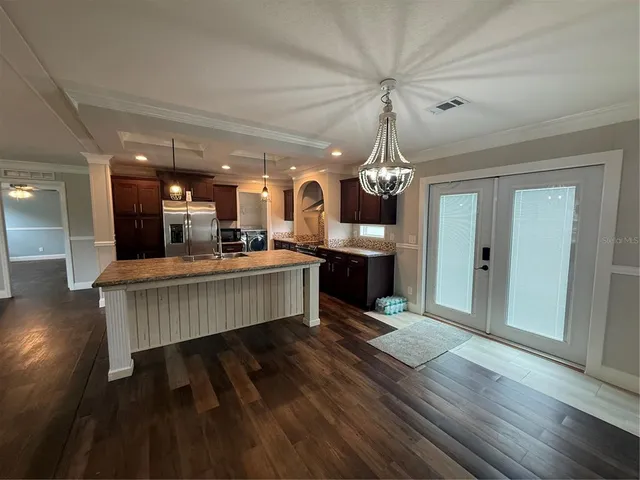 a kitchen with stainless steel appliances granite countertop a refrigerator a sink and wooden cabinets