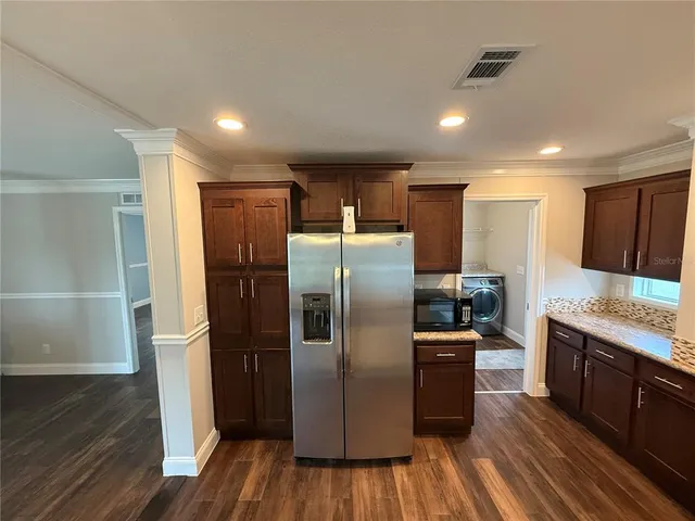a kitchen with stainless steel appliances granite countertop a refrigerator and a stove
