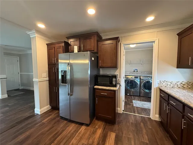 a kitchen with granite countertop a refrigerator and a stove top oven