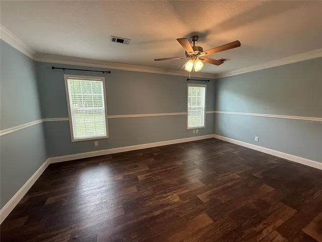 a view of a room with wooden floor and fan