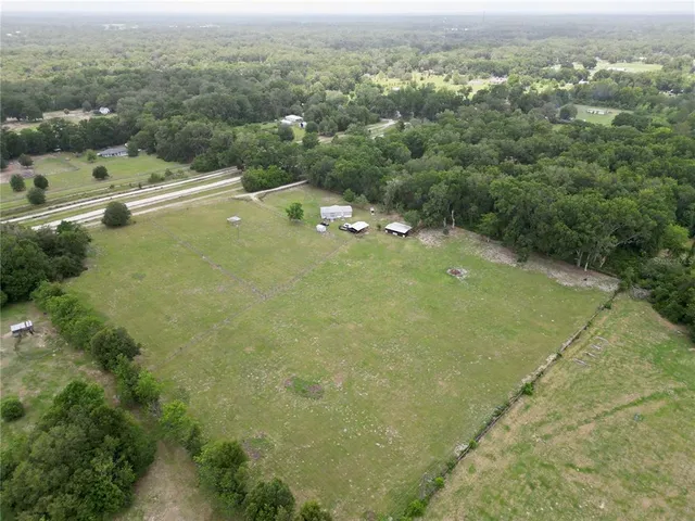a view of a backyard with table and chairs under an umbrella
