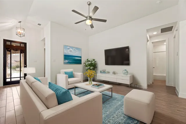 a kitchen with a dining table chairs wooden floor appliances and cabinets