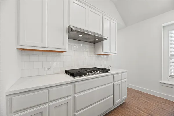 a view of a dining room with furniture a rug and wooden floor