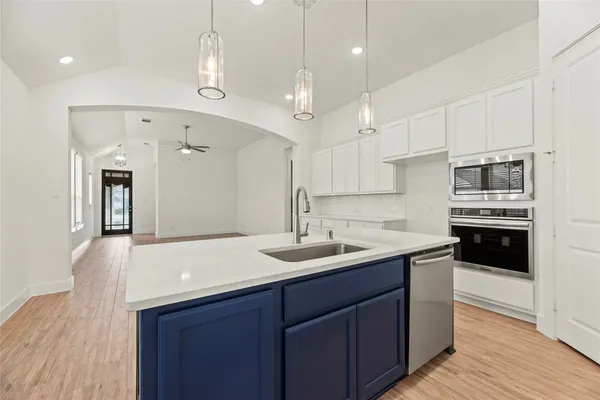a kitchen with kitchen island a sink stainless steel appliances and cabinets
