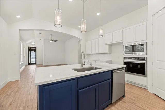a kitchen with kitchen island a sink stainless steel appliances and cabinets
