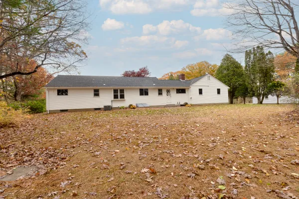 a view of a house with a yard and a bench