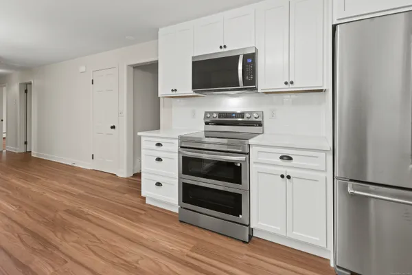 a view of a kitchen with cabinets and wooden floor