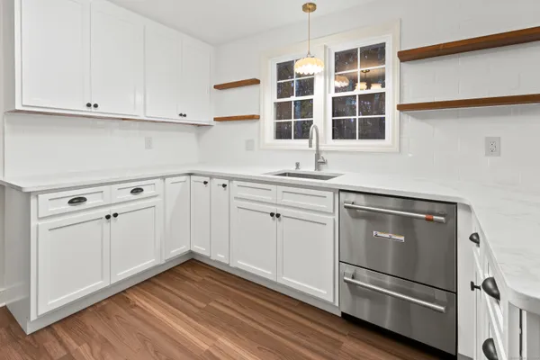 a kitchen with stainless steel appliances white cabinets and a refrigerator