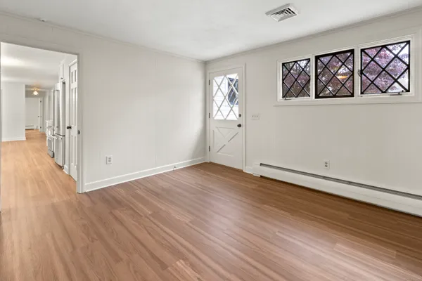 an empty room with wooden floor and windows