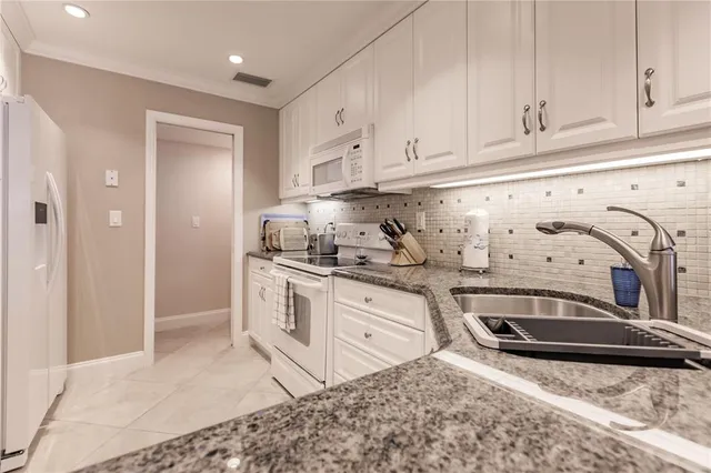a kitchen with stainless steel appliances granite countertop a sink stove and cabinets