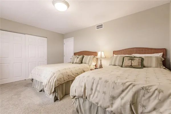a bedroom with two bed and lamp