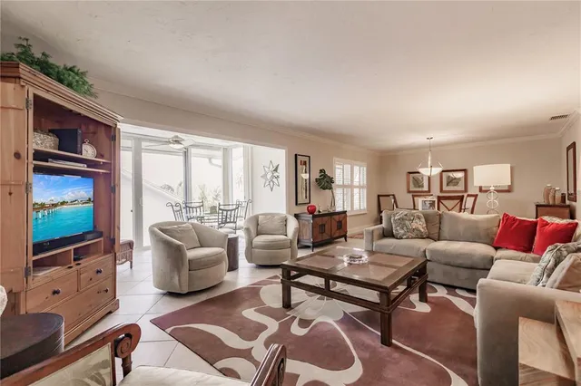 a living room with furniture a flat screen tv and a floor to ceiling window