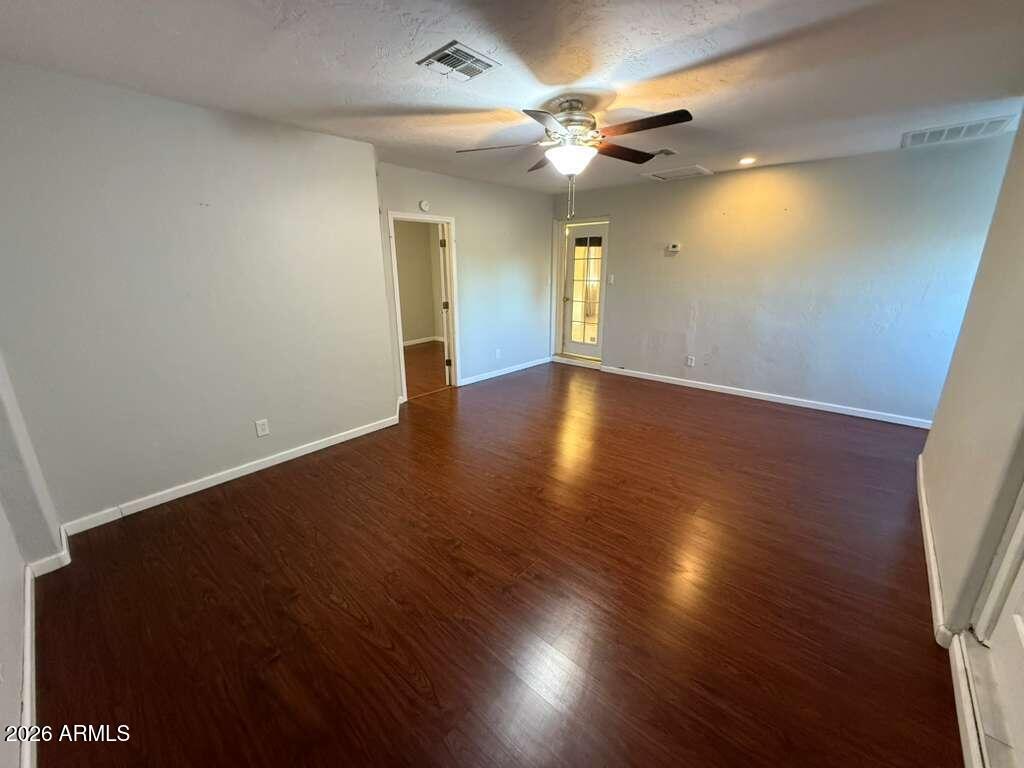 3110 East 13th Street Douglas, AZ 85607 - Photo 12 of 42 an empty room with wooden floor and windows