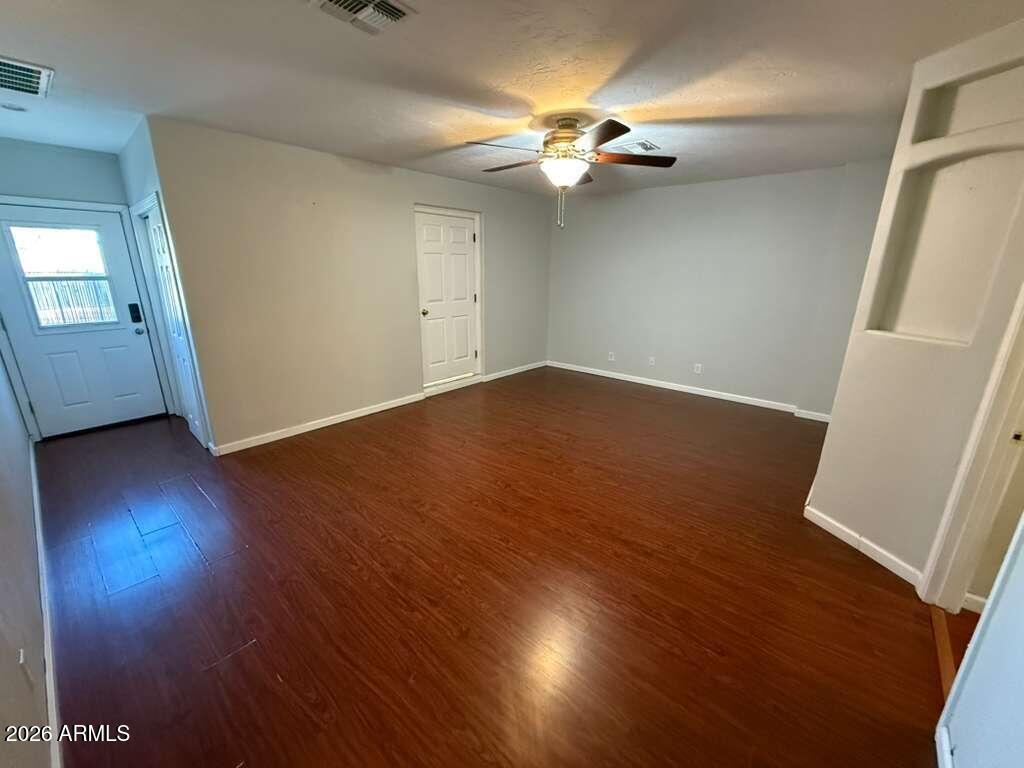 3110 East 13th Street Douglas, AZ 85607 - Photo 13 of 42 an empty room with wooden floor and windows