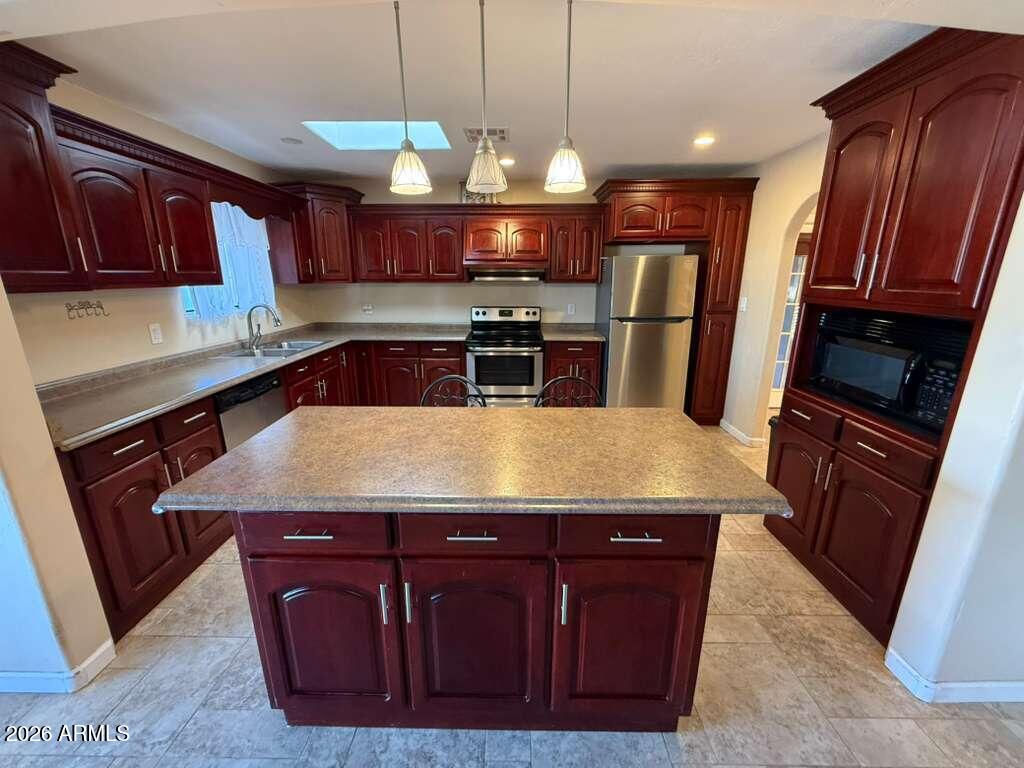 3110 East 13th Street Douglas, AZ 85607 - Photo 30 of 42 a kitchen with stainless steel appliances granite countertop wooden cabinets a stove top oven a sink and dishwasher