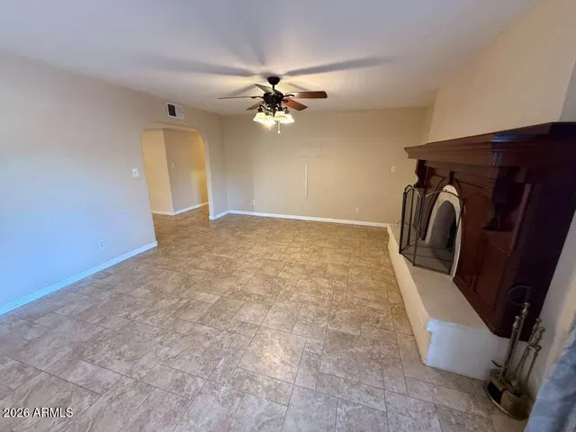 a view of a livingroom with a fireplace and a ceiling fan