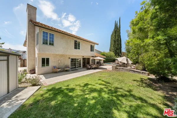 a view of a house with backyard and sitting area