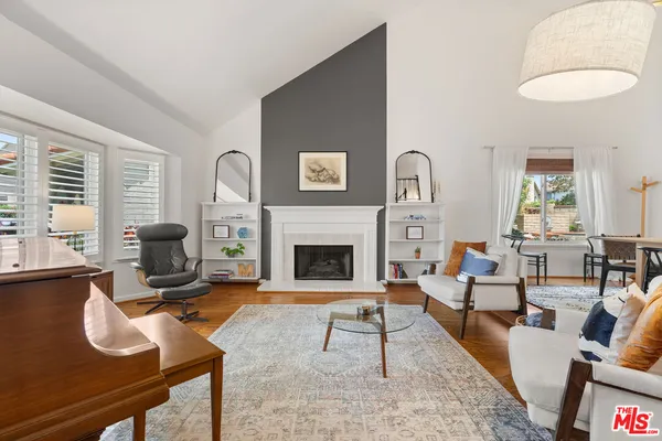 a living room with furniture a fireplace and a large window