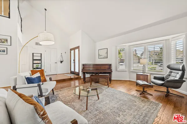 a living room with furniture a rug and a floor to ceiling window