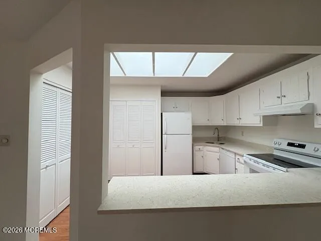a kitchen with kitchen island a refrigerator and cabinets