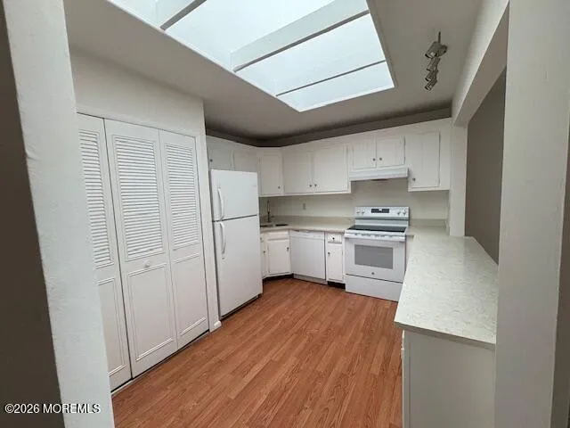 a kitchen with white cabinets and white appliances