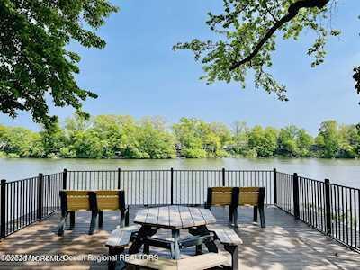 15 Lexington Court Red Bank, NJ 07701 - Photo 22 of 27 a view of a roof deck with table and chairs with wooden floor and fence