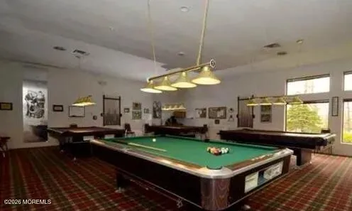 a room with pool table and windows