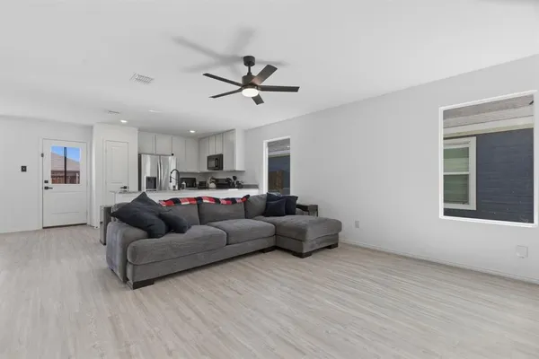 a living room with furniture and a ceiling fan