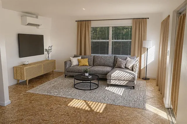 a living room with furniture a rug and a flat screen tv