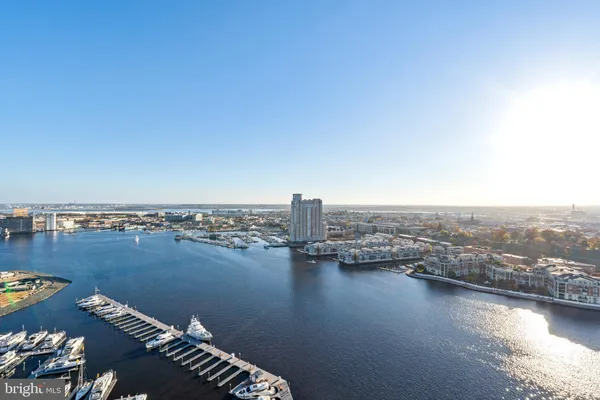 an aerial view of ocean and residential houses with outdoor space